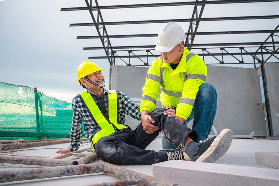 Construction site accident claim, personal injury, First Aid for Emergency Accidents at Construction Sites. Construction worker was injured in a fall from a height at a construction site. Engineers help First Aid, Safety team helps employees accident.