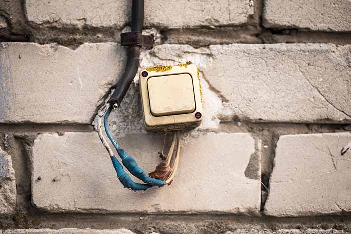 faulty electrical wiring, the old switch on the brick wall, twisted the blue tape